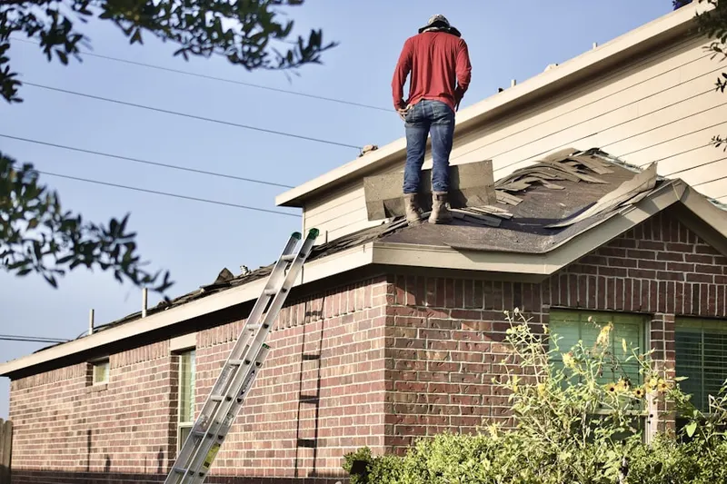 Professional roofer working on a residential roof in El Campo